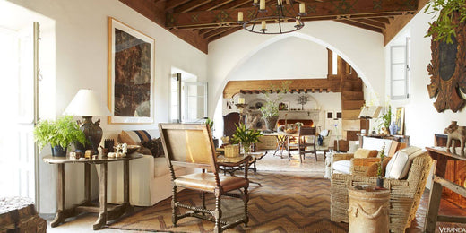 Living room with a custom wrought iron chandelier, rustic furniture, and warm natural light.