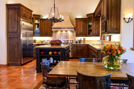 Spanish style kitchen with a dark brown chandelier hanging over the center island.