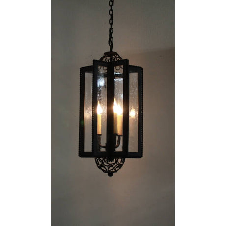 A stunning pendant light featuring a rectangular wrought iron frame with delicate detailing. Three candles illuminate the interior, surrounded by clear glass panels that enhance the elegance and warmth of the fixture. Ideal for adding a classic charm to any space.