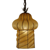 A uniquely shaped pendant light featuring a rounded top and twirling body made from frosted glass, enclosed in decorative wrought iron.