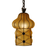 A beautifully crafted pendant light featuring an elegant, sculptural shape with a warm amber finish. The fixture is framed in intricate wrought iron, showcasing floral accents and a textured design, perfect for adding a touch of charm and sophistication to any space.