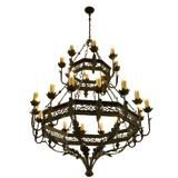 A grand chandelier featuring intricate wrought iron craftsmanship, showcasing multiple tiers adorned with candle-like bulbs and detailed leaf accents.