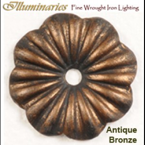 A decorative wrought iron accent in an antique bronze finish, featuring a fluted flower design with a central hole for mounting.