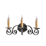 A three-arm wall sconce featuring intricate wrought iron scrollwork. Each arm holds a candle-like bulb with a warm gold base, adding an elegant touch to any space.