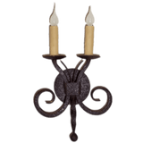 A beautiful wrought iron wall sconce featuring two candle-like bulbs atop elegantly curled arms. The textured finish and intricate design add a rustic charm, perfect for enhancing any interior space with warm illumination.