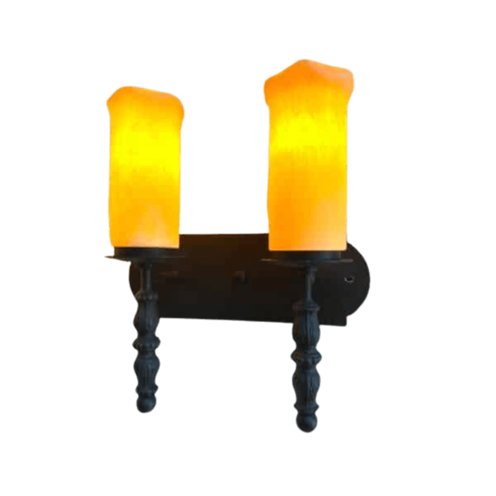 Two elegant wrought iron sconces featuring flickering amber glass shades, mounted on a dark base. The design highlights a classic aesthetic with intricate detailing.