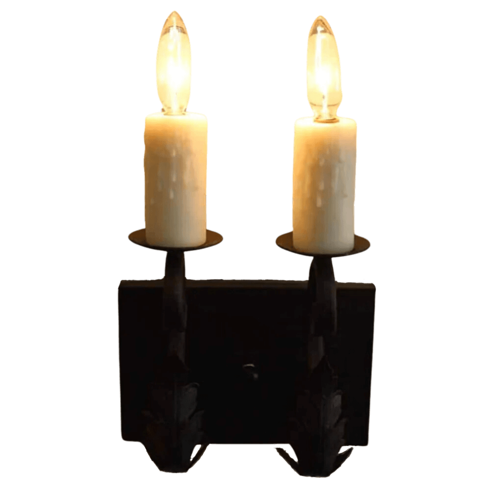 A decorative wall sconce featuring two candle-like bulbs on a black wrought iron base. The design includes intricate details and a rustic finish, ideal for adding warmth and charm to any space.