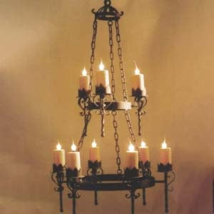 An ornate wrought iron chandelier featuring multiple candle holders with flickering flames. It hangs from a sturdy chain, showcasing intricate designs and a classic silhouette, perfect for enhancing any space with a warm, inviting glow.