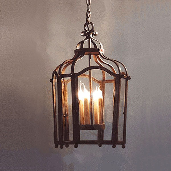 A beautifully crafted pendant with an ornate design, featuring a metal frame and glass panels. Inside, glowing candle-like bulbs create a warm ambiance, making it an elegant addition to any space.