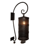 A decorative wall sconce featuring an intricately patterned cylindrical shade that houses a warm glowing light. The design includes a stylish curved arm and a textured black finish, adding elegance to any space.