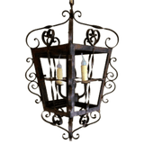 A beautifully crafted wrought iron chandelier featuring an intricate design with swirling accents and space for two candle-like bulbs. The rustic finish enhances its elegant charm, making it a stunning focal point for any room.