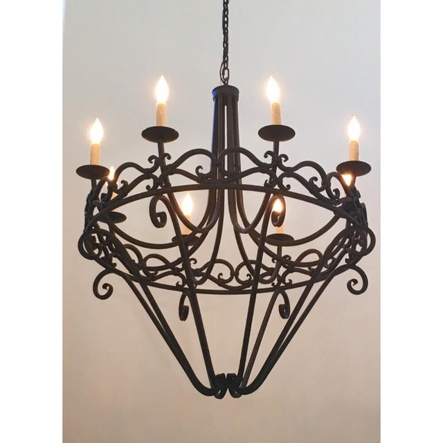 A decorative chandelier featuring elegant wrought iron craftsmanship, with six candle-like lights and intricate scrollwork. The design enhances any space with a blend of sophistication and warmth.