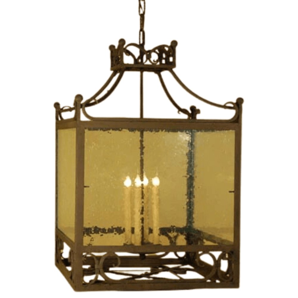 A decorative pendant lighting fixture featuring a wrought iron frame with intricate designs, complemented by four candle-like bulbs inside. The fixture has a clear, seeded glass enclosure that adds a warm glow, perfect for enhancing any space.