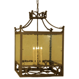 A decorative pendant lighting fixture featuring a wrought iron frame with intricate designs, complemented by four candle-like bulbs inside. The fixture has a clear, seeded glass enclosure that adds a warm glow, perfect for enhancing any space.