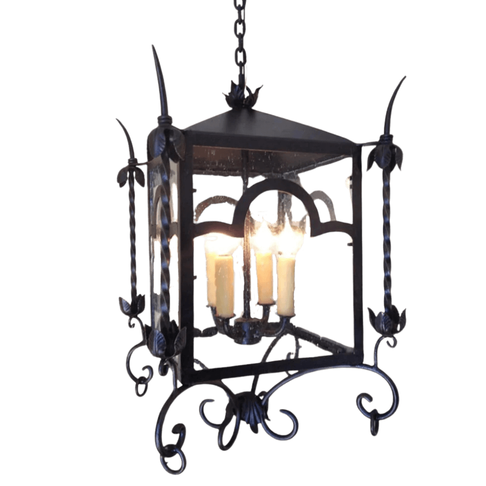 A decorative hanging fixture featuring elegant scrollwork and floral accents, housing three candle-style bulbs. The design combines rustic charm with artistic craftsmanship, ideal for enhancing any space.