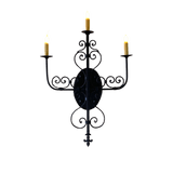 A black wrought iron sconce featuring intricate scrollwork and three candle holders, radiating elegance and charm in any space.