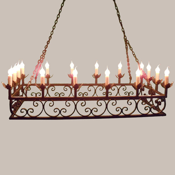 A stunning wrought iron chandelier featuring intricate scrollwork and multiple candle-style lights. Its elegant design adds a warm, inviting atmosphere to any space, suspended from a chain for a classic look.