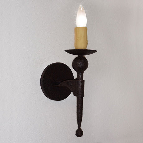 A rustic wrought iron wall sconce featuring a candle-like bulb atop a dish, supported by a spherical accent and elegant arm. Perfect for adding warm ambient light to any space.