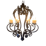 A decorative wrought iron chandelier with ornate curves and leaf designs, featuring six candle-style lights that radiate warmth and elegance.