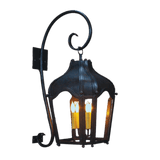 A decorative wall sconce featuring an elegant, curved design with a dark iron finish. It holds three candle-like bulbs, creating a warm glow, and is mounted against a wall, showcasing intricate detailing and craftsmanship.