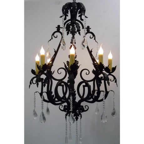 A decorative wrought iron chandelier featuring intricate scrollwork and leafy designs. It holds candles and is adorned with crystal drops, offering a blend of elegance and artistry.