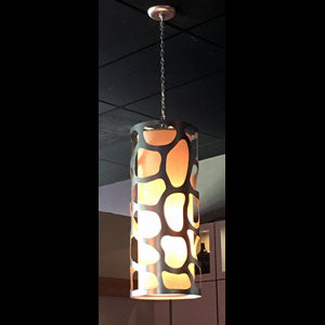 A sleek pendant light featuring a unique cut-out design that casts beautiful patterns with warm illumination. Ideal for enhancing any space with artistic flair.