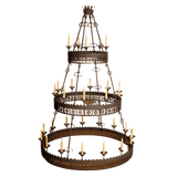 A beautifully crafted wrought iron chandelier featuring three tiers, adorned with ornate detailing and candle-style lights. The design emphasizes elegance and craftsmanship, making it a stunning centerpiece for any space.