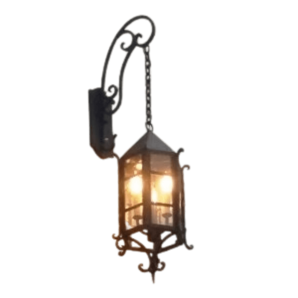 A decorative wall sconce featuring intricate wrought iron work with a warm glow emanating from inside, perfect for adding elegance to any space.