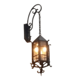 A decorative wall sconce featuring intricate wrought iron work with a warm glow emanating from inside, perfect for adding elegance to any space.