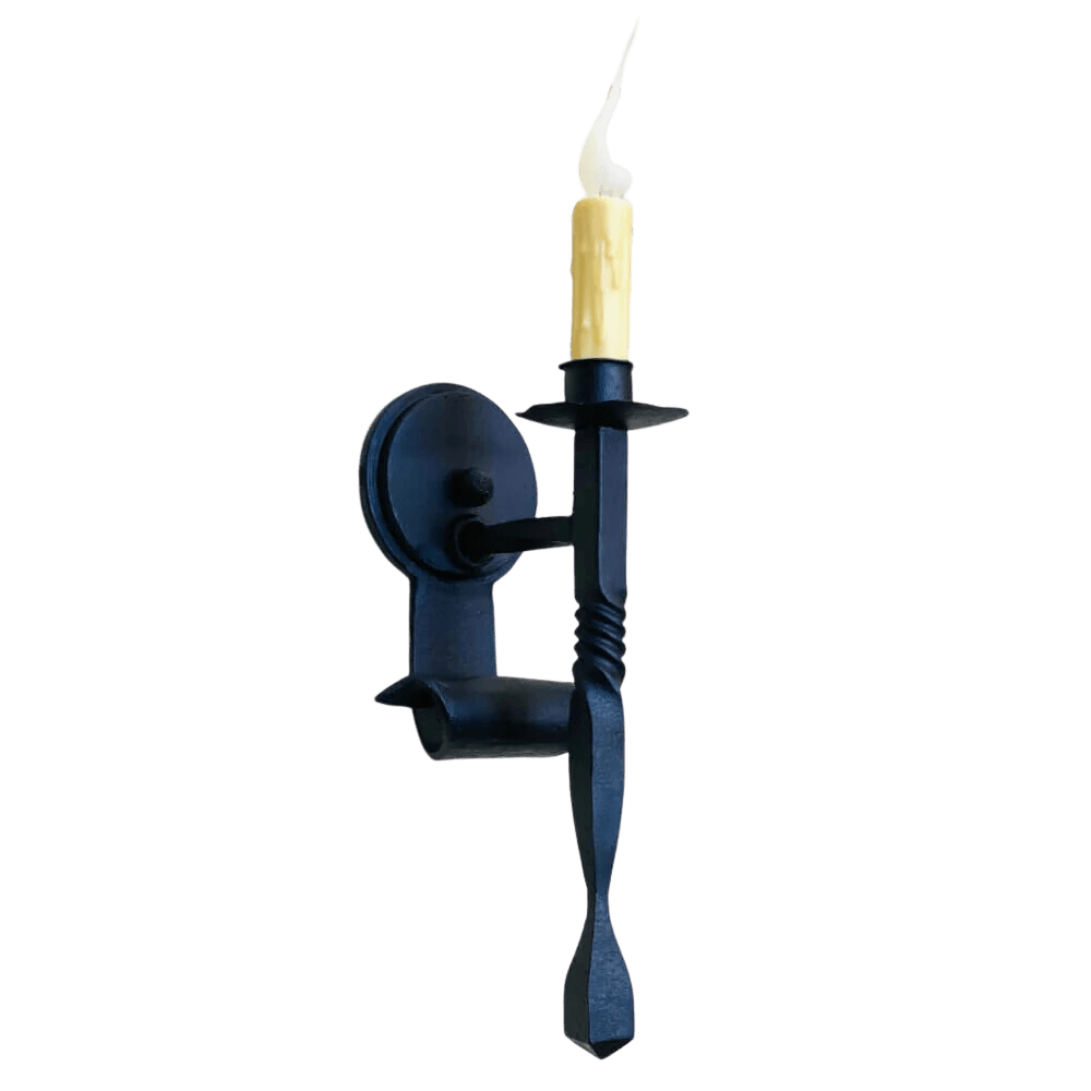 A sleek wrought iron wall sconce featuring a twisted design and a single, flickering candle. The fixture complements rustic and elegant interiors with its dark finish.