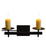 Two elegant candle sconces featuring yellow wax candles atop circular plates. The wrought iron structure is dark and minimalist, blending rustic charm with modern aesthetics, perfect for enhancing any space's cozy atmosphere.