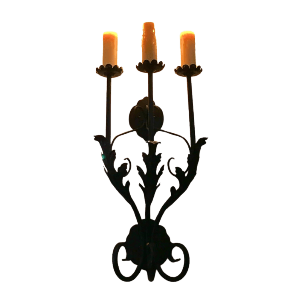 A beautifully crafted wrought iron sconce featuring three elegant candle holders. The design showcases intricate leaf patterns and a classic, elegant style that enhances any ambiance.