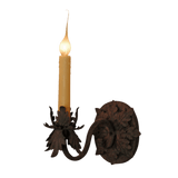 A beautifully crafted wrought iron sconce featuring an elegant candle-like light. The design incorporates intricate floral elements and a classic curling arm, enhancing any decor with a warm, inviting glow.