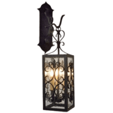 Wrought iron wall sconce featuring intricate scrollwork and a rectangular shape. It has a classic black finish and glass panels, showcasing four light bulbs.