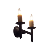 A classic wrought iron wall sconce featuring two candle-style lights. The fixture has a rustic black finish, perfect for adding warmth and elegance to any space.