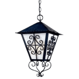 A decorative pendant light featuring intricate wrought iron scrollwork and a multi-faceted glass design. The metal shade has a peaked roof and elegant detailing, creating a warm, inviting ambiance.