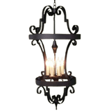 A beautifully crafted wrought iron chandelier featuring elegant curves and intricate details. It holds multiple candle-like lights, creating a warm and inviting ambiance. The design highlights traditional craftsmanship, making it a perfect statement piece for both rustic and elegant interiors.