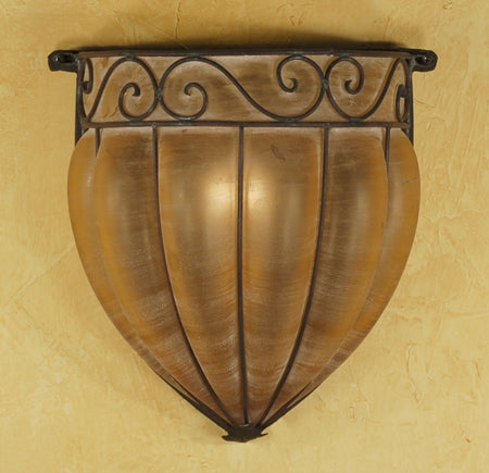 A decorative wall sconce featuring a curved, bowl-like shade in a warm metallic finish, accented with intricate wrought iron detailing on top.