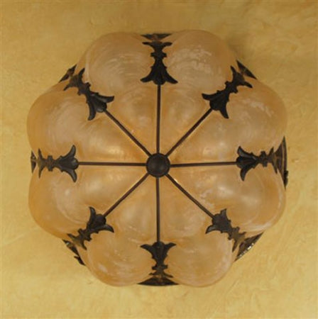 A detailed overhead view of a decorative light fixture featuring ornate wrought iron accents and a soft, rounded glass shade with a warm amber hue. The design showcases graceful curves and intricate patterns, ideal for enhancing the ambiance of any space.