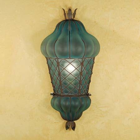 A decorative wall sconce featuring a unique shape with a glass shade in a rich teal hue, highlighted by intricate wrought iron detailing. The fixture has an elegant, vintage-inspired design, adding charm and character to any space.