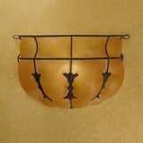 A beautifully crafted wall-mounted sconce featuring a curved amber glass shade, elegantly framed with intricate wrought iron detailing. The design highlights artistic flourishes that enhance its warm glow, perfect for adding charm to any space.