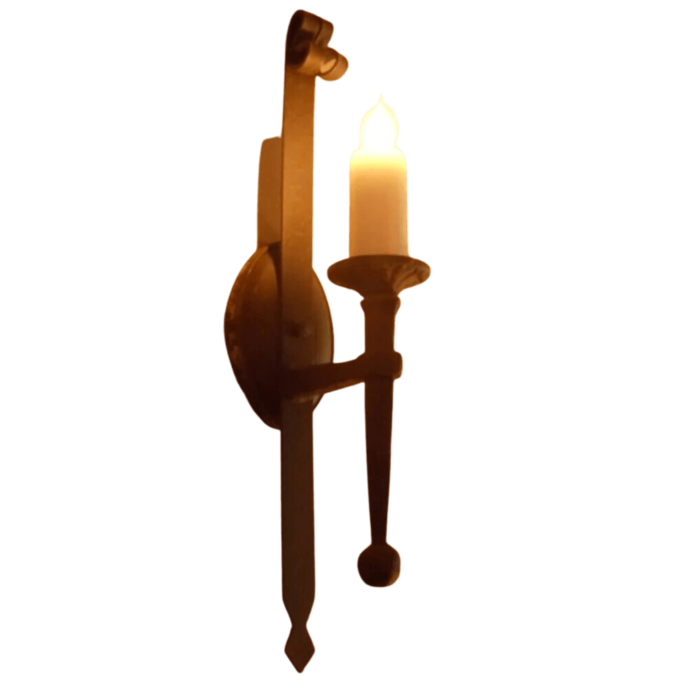 A beautifully crafted wrought iron sconce featuring a candle holder with a flickering light. The design includes elegant scrollwork and a decorative backplate, adding a warm and inviting ambiance to any space.