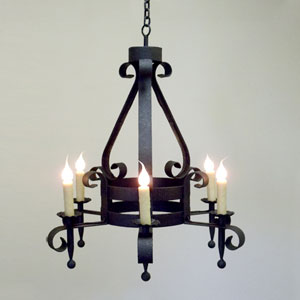 A beautifully crafted wrought iron chandelier featuring elegant scrollwork and six candle-style lights. This piece combines rustic charm with refined artistry, perfect for enhancing any space.