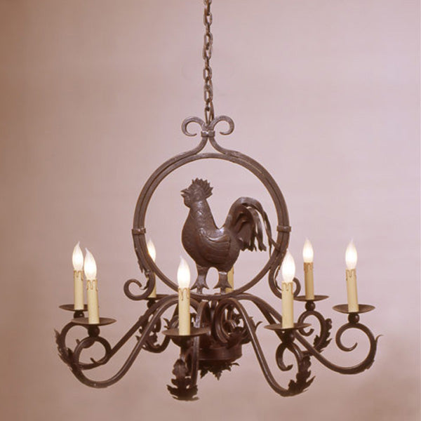 A decorative wrought iron chandelier featuring a central rooster motif, six candle-like bulbs, and elegant swirling accents. Perfect for adding rustic charm to any space.