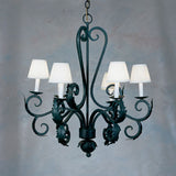 A graceful wrought iron chandelier featuring elegantly curved arms adorned with intricate leaf designs. It includes four white lampshades, providing a soft, ambient glow. The piece combines artistry and functionality, perfect for enhancing any space.