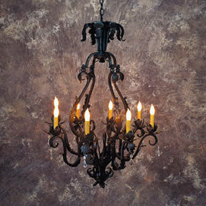 A beautifully crafted wrought iron chandelier featuring intricate scrollwork and six elegantly curved arms, each adorned with warm glowing candles. The design exudes a classic charm and sophistication, perfect for adding a touch of elegance to any space.