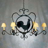 A decorative wrought iron chandelier featuring six arms with cream-colored shades, showcasing a silhouette of a rooster in the center. Ideal for adding rustic charm to any space.