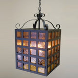 A beautifully crafted wrought iron pendant light featuring a square shape with textured, colored glass panels. The fixture hangs gracefully from a stylish chain, adding warmth and charm to any space.