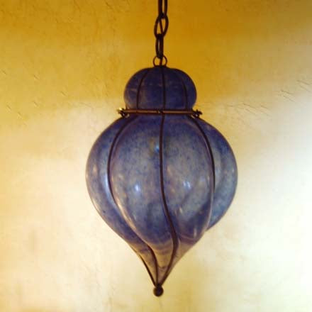 A beautifully crafted pendant light featuring an intricate glass design in shades of blue, accented with wrought iron detailing. The elegant, bulbous shape enhances any space, making it a unique focal point.