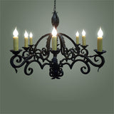 A beautifully crafted wrought iron chandelier featuring an ornate design with six candle-like bulbs set on curved arms, adding elegance and warmth to any space.